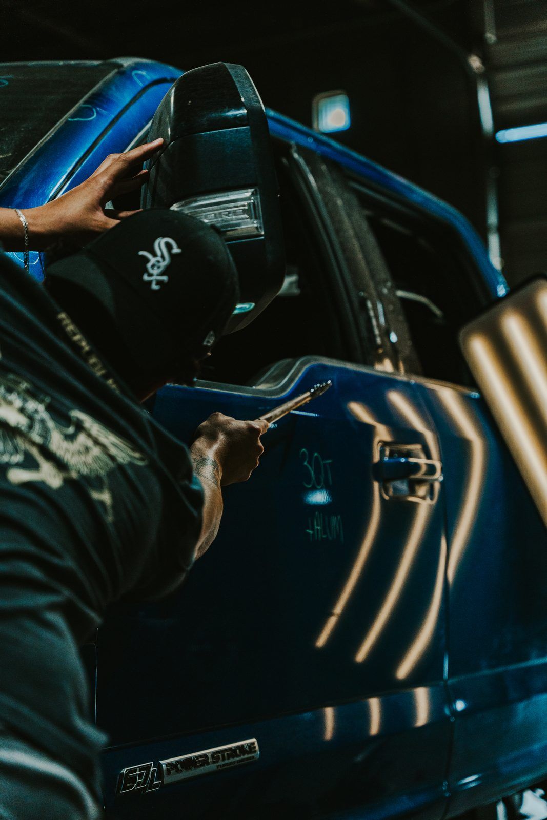 Technician repairing a fender dent with paintless dent repair